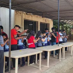 My coaches providing one-on-one guidance to students during a school workshop. This personal attention helps demystify the sport and builds confidence in young, first-time shooters.
