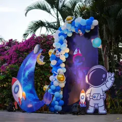 A photo booth corner for the space-themed party, featuring an astronaut cutout and a rocket on the moon, perfect for capturing fun memories.