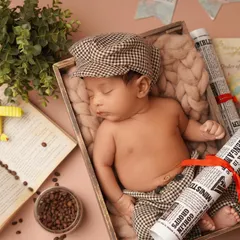 A wider shot of the traveler-themed newborn setup, showing how all the elements come together. The baby is nestled safely in a wooden crate, dreaming of future adventures.