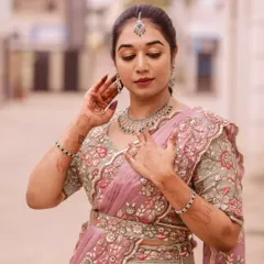 This bride looks elegant in a pastel pink and grey lehenga. The makeup is soft and romantic, with a focus on glowing skin and beautifully defined eyes.