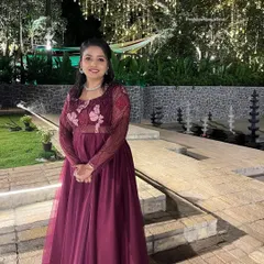 The same client in her custom wine-colored gown, pictured in a different setting. The sheer sleeves and butterfly motifs on the bodice are clearly visible here.