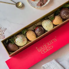 A sleek red box opened to show an assortment of chocolate-covered strawberries, decorated with different drizzles and sprinkles. This is a classic romantic gift, elevated with my artisanal touch.
