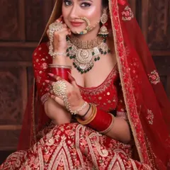 This is a perfect example of a complete bridal rental package. The deep red lehenga is paired with a heavy Kundan and green beaded jewellery set, nath, and haath phool for a stunning look.