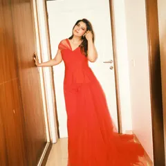 The full, dramatic silhouette of the custom Gauri and Nainika red gown with its long tulle train.
