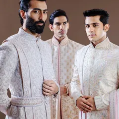 Three distinct personalities, one standard of excellence. This image displays the variety within our sherwani collection, from subtle textures to more pronounced embroidery, catering to the unique style of every groom and groomsman.
