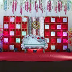 For a bold and glamorous reception, I created this stage with a striking red and white checkered backdrop and a custom gold monogram. The ornate silver sofa and hanging floral elements complete this high-impact look.