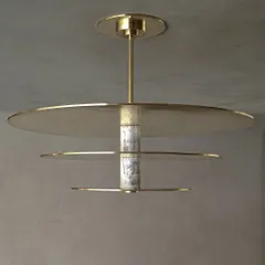 A detailed view of our custom ceiling light, where we explored the interplay between materials. The fixture combines cool, veined marble with the warmth of spun brass discs, creating a sculptural centerpiece for an entrance foyer.