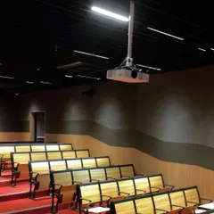 A closer look at the auditorium project, showing how wall washers and recessed linear lights create a professional and focused environment. The lighting is designed to be functional and non-distracting, ensuring the audience's attention remains on the stage.