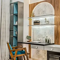 A stylish and modern study nook featuring an arched, textured back panel with integrated lighting. The combination of wood, metal, and a pop of teal in the chair creates an artistic and inspiring corner.