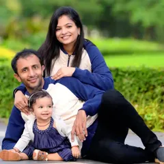 A relaxed family portrait taken in a local park, with parents and their young daughter sitting together. We find the best spots with soft, natural light to create warm and inviting family photos.