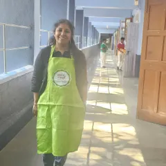 In my element, wearing my art apron in the school corridor. I am always ready to conduct a fun and engaging workshop.