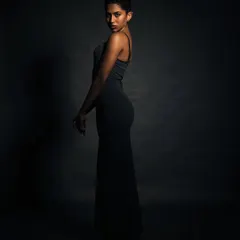 A silhouette-style portrait that focuses on the model's form and posture. The minimal light creates a classic and elegant feel.
