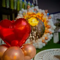 A close-up shot of the details in my outdoor setups. Here you can see a bright red heart-shaped foil balloon, which adds a pop of color to the elegant white and bronze balloon arrangement.