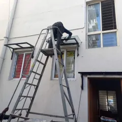 Here you can see my team member installing a custom-fabricated glass and metal awning. These are perfect for protecting windows and doorways from rain and sun without blocking the light.