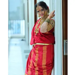 A classic pose for my beautiful Iyer bride. Her makeup features a soft, golden glow and defined eyes, perfectly complementing her red nine-yard saree and traditional gold jewellery.