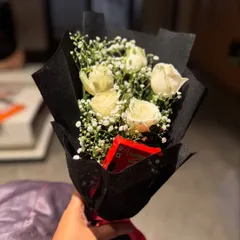 A classic and elegant gesture. This hand-tied bouquet of white roses with a touch of baby's breath is perfect for any occasion, or just because.