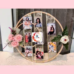 A unique and creative way to display memories. This custom gift features a large hoop decorated with flowers and ribbons, holding a series of cherished photographs.