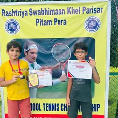 Two of our DDA Tennis Tournament achievers, Garvit Gupta and another young player, proudly displaying their medals, certificates, and trophies.