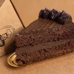 A close-up of a slice of my low-carb Ultimate Chocolate Cake. You can see the moist almond flour sponge and the rich layers of sugar-free chocolate fudge. It's the perfect treat for any diabetic or keto diet follower.