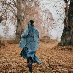 A shot capturing movement and freedom. The model runs through the woods, the flow of her jacket mimicking the natural energy of the surroundings.
