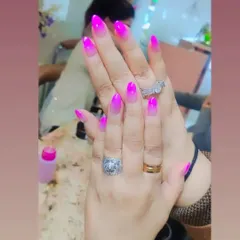 A bright and bold pink ombre effect on almond-shaped nails. This vibrant color transition is perfect for summer or anytime you want a fun pop of color.