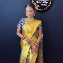A full-length view of a South Indian bride in a stunning yellow silk saree, showcasing the complete look with temple jewelry and a perfectly draped saree.