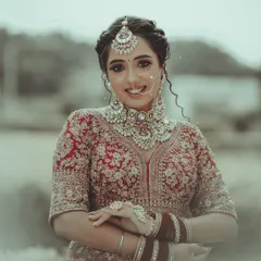 The joy of a bride shines through in her smile. This is a beautiful, candid-style portrait that captures her happiness and the exquisite details of her wedding jewelry and attire.