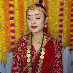 A serene portrait of a flawless Nepali bride. Her makeup is kept classic and clean with a red lip and subtle eye makeup to let her traditional attire and unique coin necklace shine.