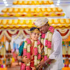 An intimate moment between the bride and groom during their wedding ceremony, surrounded by traditional decor.