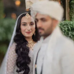 An artistic portrait with the bride in sharp focus and the groom softly blurred, creating a beautiful and romantic composition.