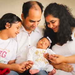 The whole family admiring their newest member. This at-home newborn session shows how we include older siblings, like this proud big sister.