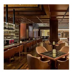 The hotel bar at the Sheraton, where we used dark wood, plush seating, and dramatic pendant lighting to create an intimate and upscale atmosphere. This is an example of our custom hospitality interior concepts.