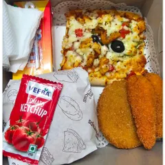 A complete meal in a box. This birthday snack box includes a chicken burger, a slice of tandoori chicken pizza, chicken cutlets, and ketchup.