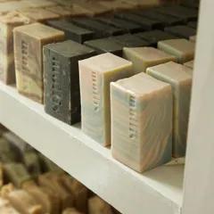 A close-up of the curing rack, showing the variety of soaps I have in stock, from the dark Oudh Charcoal to the pastel Aqua bars.