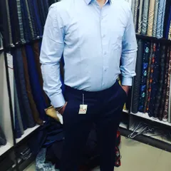 A client trying on his new light blue formal shirt and navy trousers in my shop. This classic combination is a staple for office wear, and a custom fit makes all the difference.