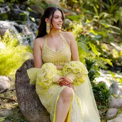 A solo portrait of the bride-to-be from the garden shoot. Her vibrant yellow lehenga with unique puff sleeves stands out beautifully against the natural greenery, showcasing her unique bridal style.