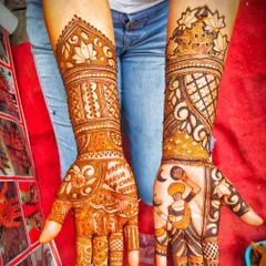 A perfect Karva Chauth mehendi design. One hand shows the wife looking at the moon through a sieve, a classic ritual of the festival. The other hand wishes 'Happy Karva Chauth'.