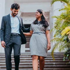 A natural shot of a couple walking down the steps of a classic building, capturing a simple, happy moment together.