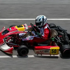 A side profile of our number 50 kart at full throttle on the main straight, highlighting the aerodynamic design and stability of our Birel ART chassis.