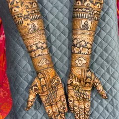 This full-arm bridal design is a masterpiece of symmetry and detail. It features personalized initials, elephant motifs, and palace-inspired architecture, all woven together with classic jaali (net) patterns.
