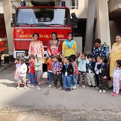 Our entire group poses proudly in front of a fire truck. These community outings help children understand the world around them and the important roles people play in it.