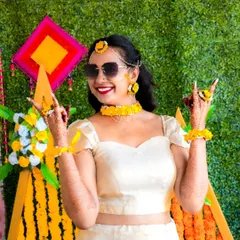 A cool and happy bride enjoying her Haldi ceremony. The sunglasses and fun pose show her personality, making for a great, memorable shot.
