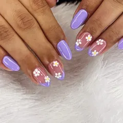 We love a floral moment. This pretty set features delicate white and yellow daisies on a sheer base, paired with a lovely lavender purple on the other nails for a fresh, spring-inspired look.