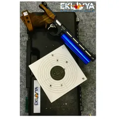 A close-up of a high-precision air pistol and a target sheet showing a tight grouping of shots. We provide access to Olympic-grade equipment to help every shooter achieve their best performance.