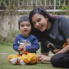 A picture filled with love and endless smiles. This candid moment between a mother and her son on the grass captures their heartwarming bond.