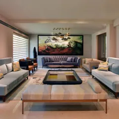Here you can see the result of the renovation. The living room is now a single, expansive space, yet it contains multiple seating areas that feel distinct and intimate. The pastel palette enhances the newfound lightness and airiness.