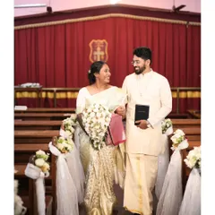 Roshan and Ria, walking down the aisle as a married couple. Dressed in traditional white and gold attire, their joy illuminates the church, which we decorated with simple, elegant floral arrangements on the pews.