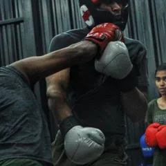 Getting comfortable with contact is crucial. In this shot, a student learns to handle pressure and keep her guard up while her partner works.