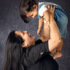 The pure joy of being lifted up by mom. We focus on capturing the dynamic, playful, and loving interactions that define your family's bond.