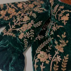 A close-up view of the dense zardosi and sequin work on the sleeve of our green velvet blouse, highlighting the texture and craftsmanship.